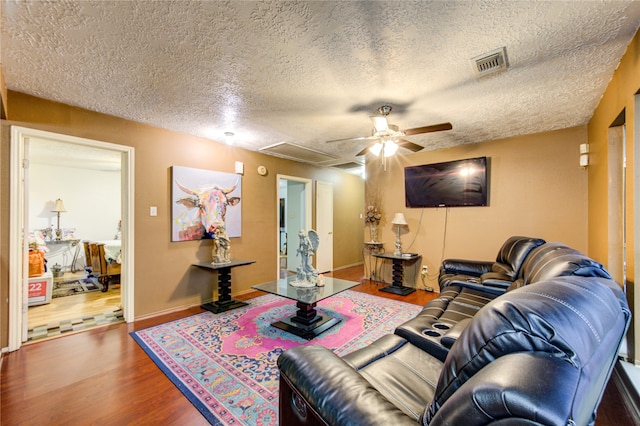 living room with hardwood / wood-style floors, a textured ceiling, and ceiling fan