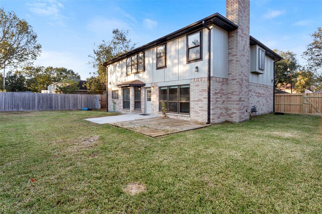 back of property with a patio area and a lawn