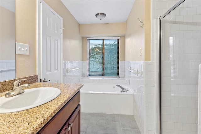 bathroom with vanity, tile walls, separate shower and tub, and tile patterned flooring