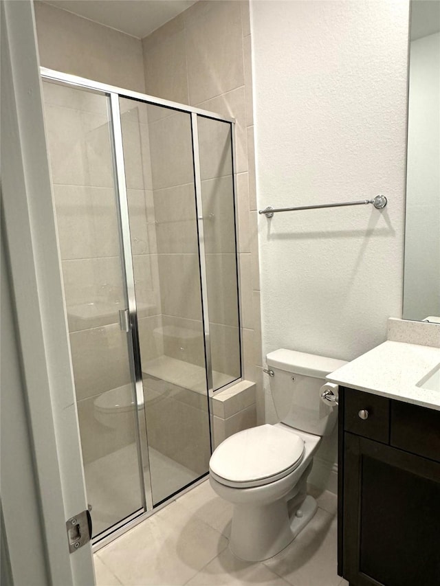 full bathroom with toilet, a shower stall, tile patterned flooring, and vanity