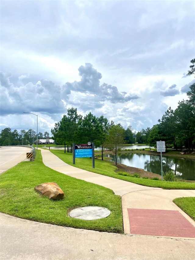 view of home's community featuring a water view and a lawn