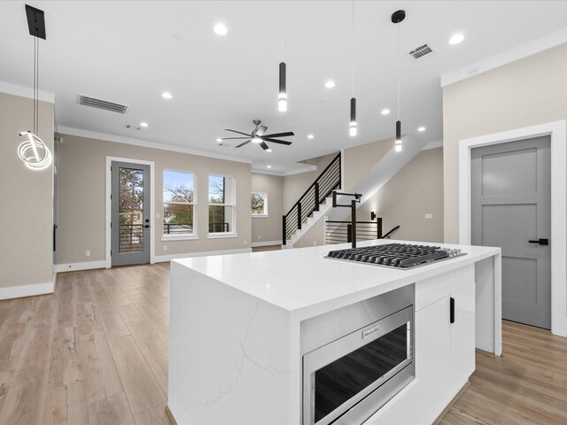 kitchen with pendant lighting, a center island, white cabinetry, and appliances with stainless steel finishes