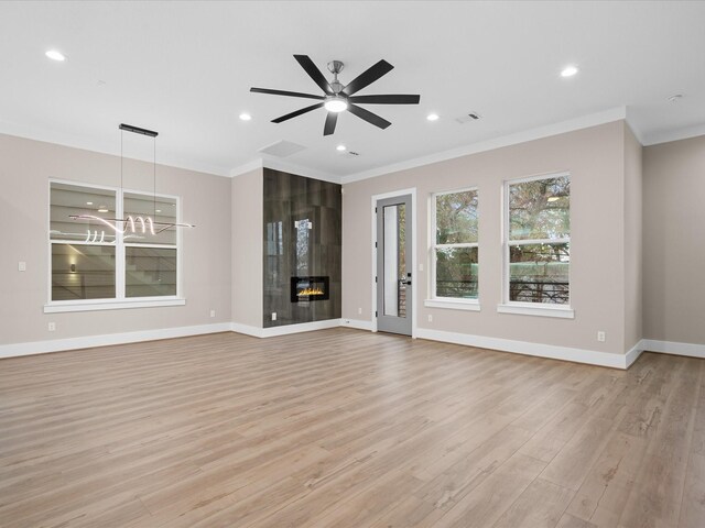 unfurnished living room featuring a fireplace, light wood-type flooring, ceiling fan, and crown molding