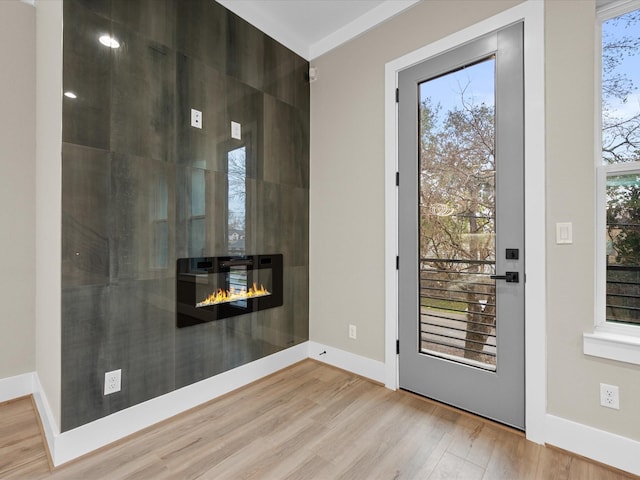 doorway to outside featuring light hardwood / wood-style floors and a fireplace