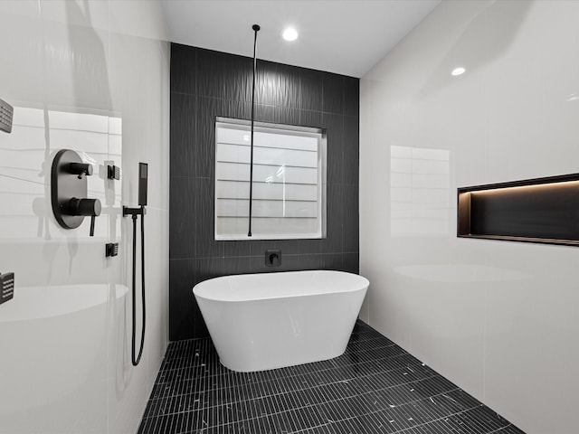 bathroom featuring a tub, tile walls, and tile patterned flooring