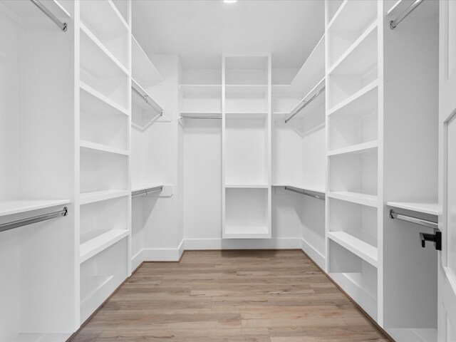 walk in closet with light hardwood / wood-style floors