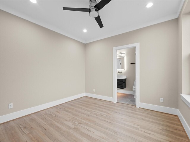 unfurnished bedroom with ceiling fan, ensuite bath, and light wood-type flooring