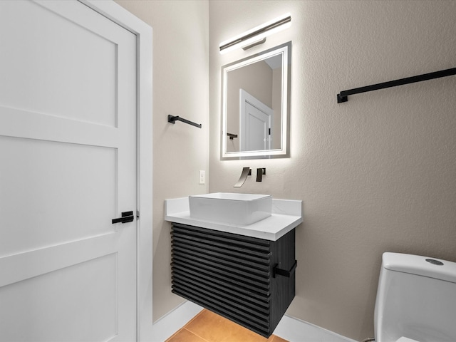 bathroom with toilet, tile patterned floors, and vanity