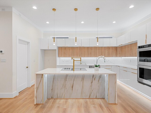 kitchen with decorative light fixtures, white cabinets, a kitchen island with sink, and black electric stovetop