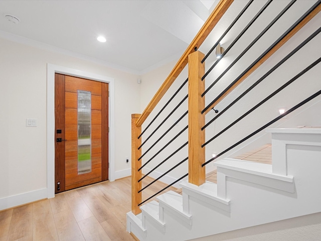 entrance foyer with light wood-type flooring and crown molding