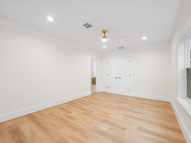 empty room with ceiling fan, light hardwood / wood-style flooring, and crown molding