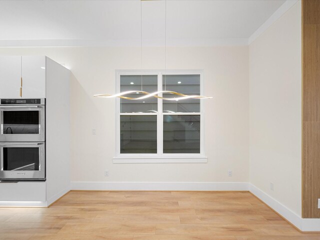 kitchen with light hardwood / wood-style floors, white cabinetry, double oven, and crown molding