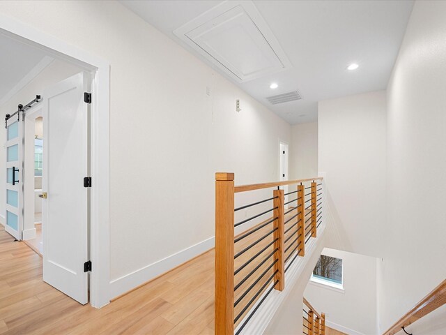 corridor featuring a barn door and hardwood / wood-style floors