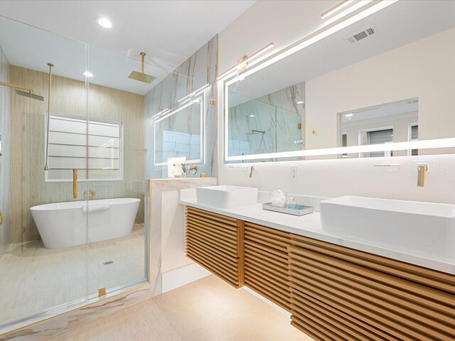 bathroom with vanity, tile patterned flooring, and plus walk in shower