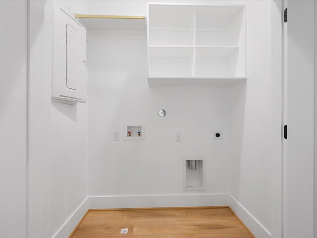 washroom featuring gas dryer hookup, hardwood / wood-style flooring, hookup for a washing machine, electric dryer hookup, and electric panel