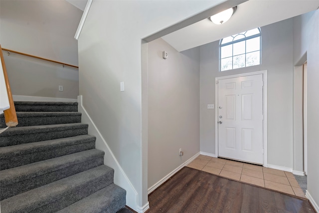 foyer entrance featuring wood-type flooring and a high ceiling