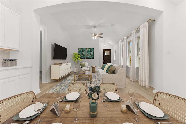 dining space with light hardwood / wood-style flooring, lofted ceiling, and ceiling fan