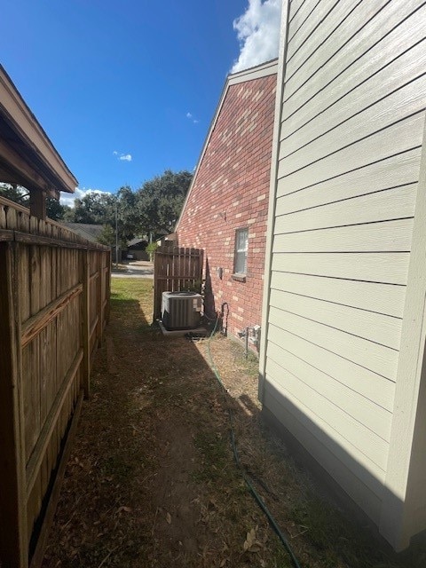 view of side of home with central air condition unit