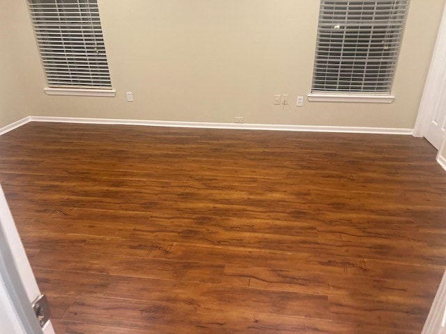 unfurnished room with dark hardwood / wood-style flooring