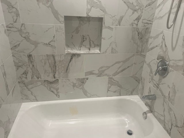 bathroom featuring tiled shower / bath