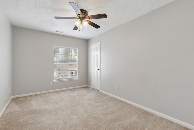 carpeted spare room featuring a textured ceiling and ceiling fan