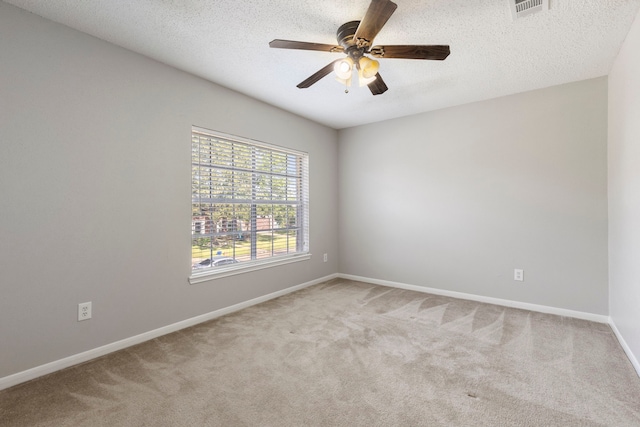 empty room featuring a textured ceiling, light carpet, and ceiling fan