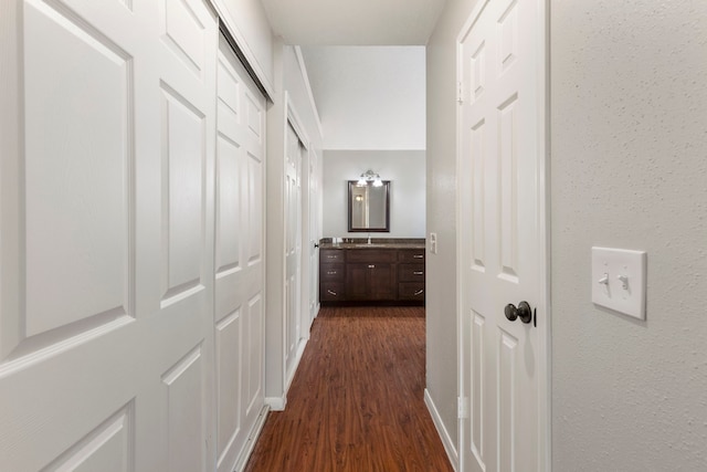 corridor with dark wood-type flooring and sink