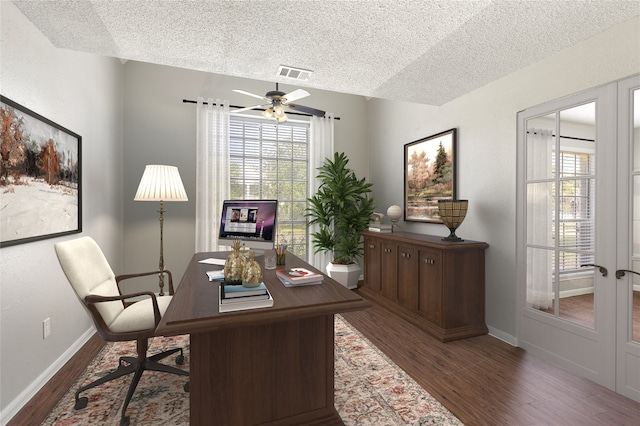 office with dark wood-type flooring, a healthy amount of sunlight, and a textured ceiling