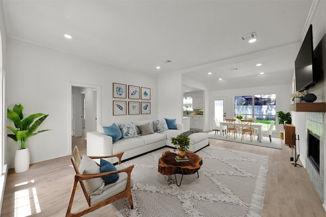 living room featuring crown molding and light hardwood / wood-style flooring