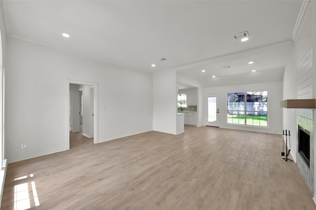 unfurnished living room with ornamental molding, light wood-type flooring, and a fireplace