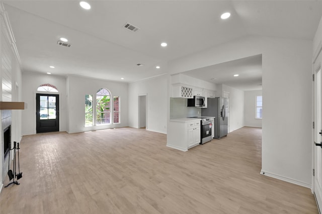 kitchen featuring white cabinetry, light hardwood / wood-style floors, appliances with stainless steel finishes, and ornamental molding