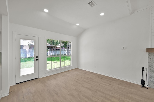 unfurnished living room with vaulted ceiling and light wood-type flooring