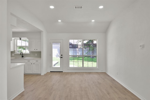 interior space with sink, light hardwood / wood-style flooring, vaulted ceiling, and ceiling fan