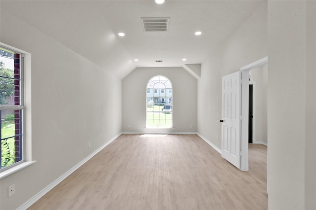 unfurnished room with light hardwood / wood-style flooring and vaulted ceiling