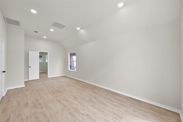 empty room featuring light hardwood / wood-style floors and vaulted ceiling