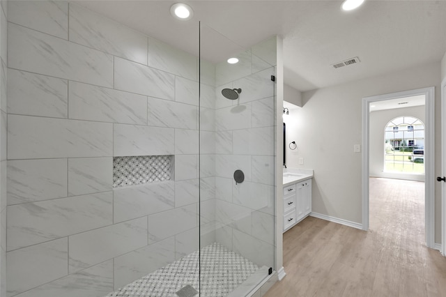 bathroom with vanity, wood-type flooring, and tiled shower