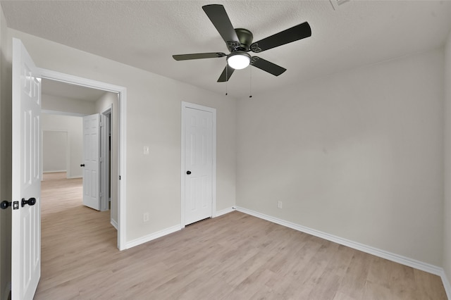 unfurnished bedroom featuring light hardwood / wood-style flooring, a textured ceiling, and ceiling fan