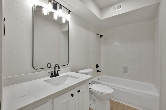 full bathroom featuring toilet, tiled shower / bath, vanity, and wood-type flooring