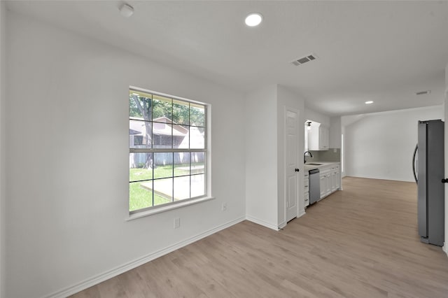 kitchen featuring light hardwood / wood-style flooring, white cabinets, stainless steel appliances, and sink