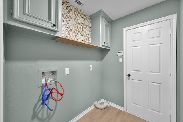 laundry area featuring cabinets, washer hookup, and wood-type flooring