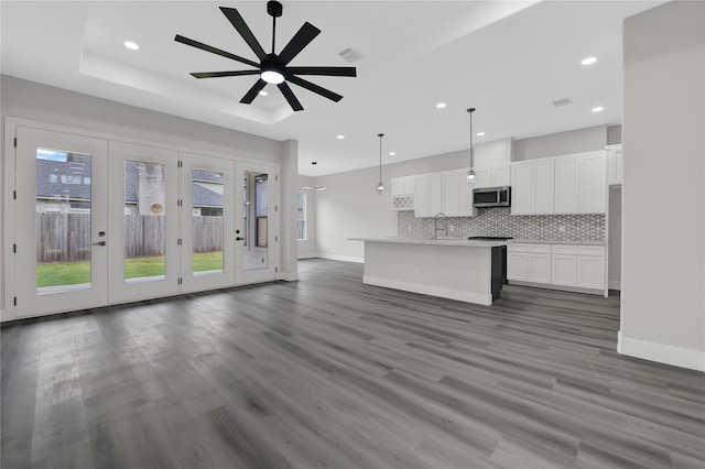 unfurnished living room with sink, french doors, dark hardwood / wood-style floors, and ceiling fan