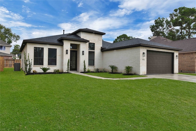 view of front of house featuring a front yard, central AC, and a garage