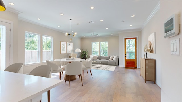 dining room featuring light hardwood / wood-style flooring, a healthy amount of sunlight, ceiling fan, and crown molding