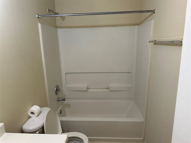 bathroom with bathtub / shower combination and toilet