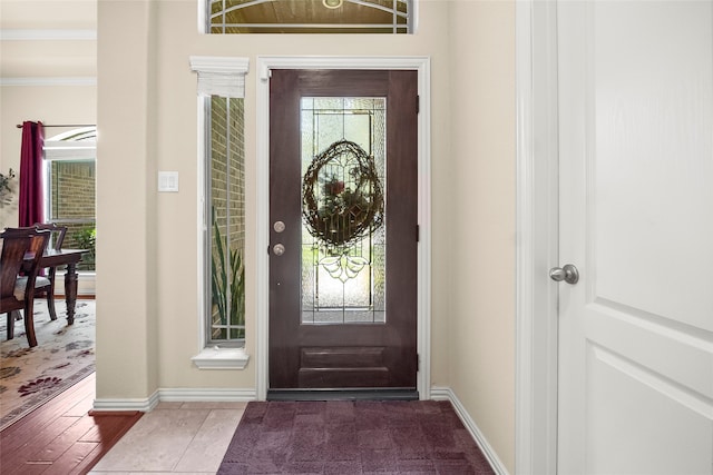 foyer featuring ornamental molding and dark wood-type flooring