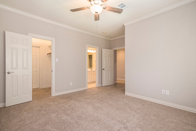 unfurnished bedroom featuring a walk in closet, ceiling fan, connected bathroom, ornamental molding, and light colored carpet