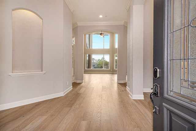 foyer featuring ceiling fan, ornamental molding, and light hardwood / wood-style flooring