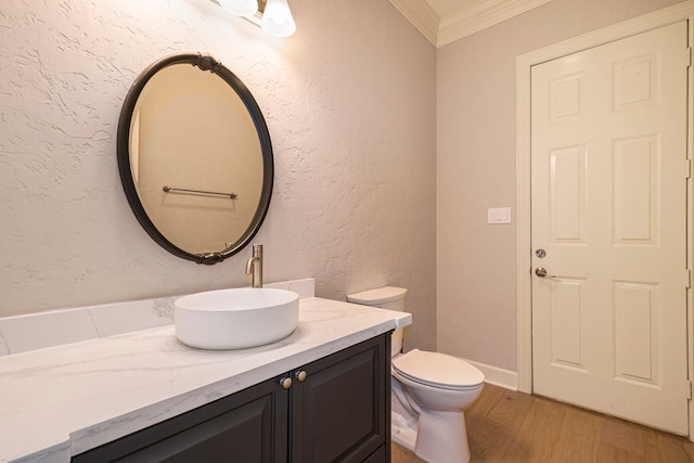 bathroom with vanity, toilet, hardwood / wood-style flooring, and crown molding