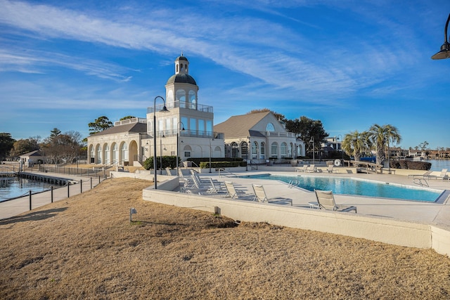 view of pool featuring a patio area and a water view