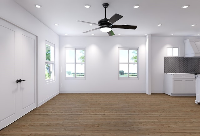 unfurnished living room with a wealth of natural light, light hardwood / wood-style floors, and ceiling fan